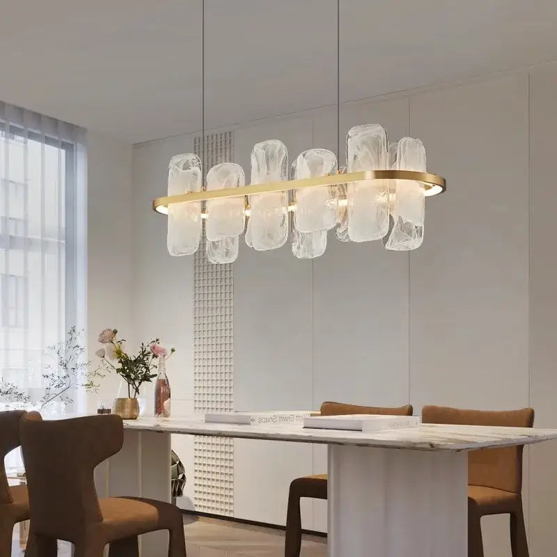 A decorbites led pendant light chandelier with a gold circular frame and translucent glass elements above dining table
