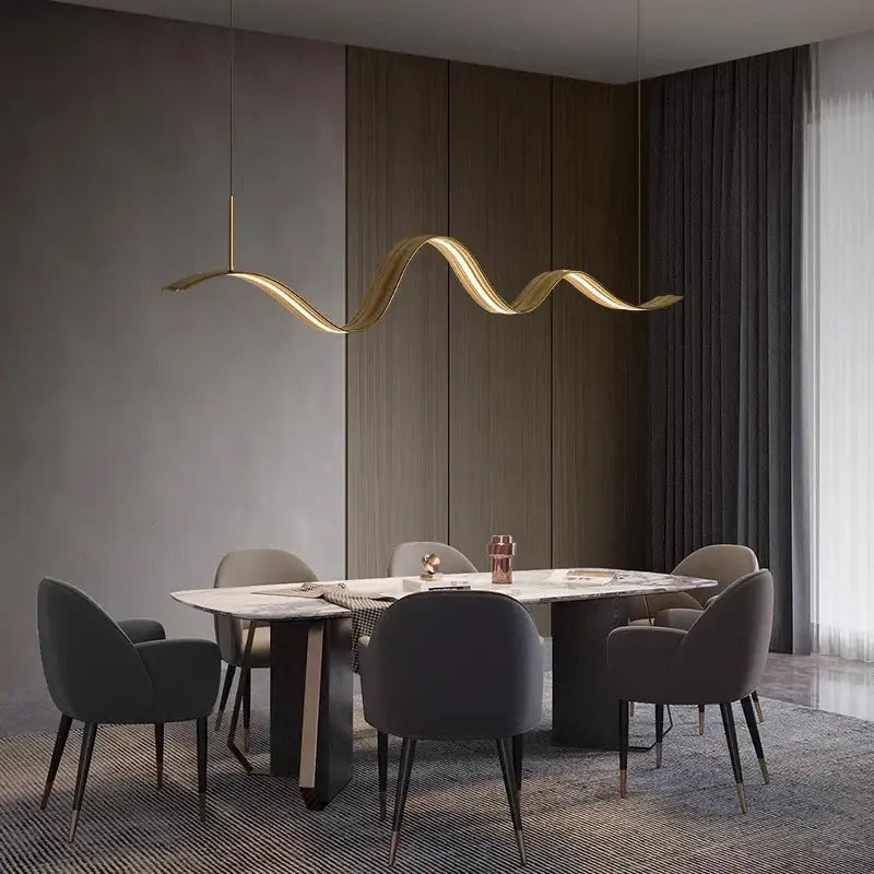 Golden wave-shaped decorbites led pendant light with sleek metallic finish hanging above dining table for modern decor