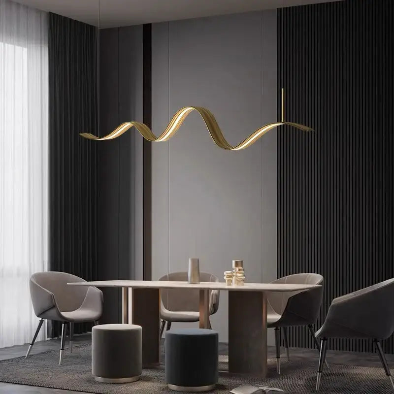 A sleek golden wave-shaped decorbites led pendant light hangs above a dining table for modern living and dining rooms