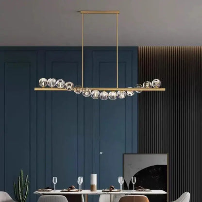 Gold-toned DecorBites LED pendant chandelier with sleek bar and faceted crystal spheres for modern living and dining rooms