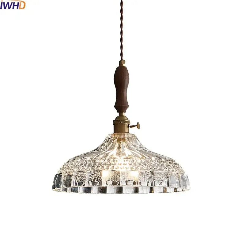 Decorbites led pendant light featuring clear intricately patterned glass with dark wood handle and brass accents