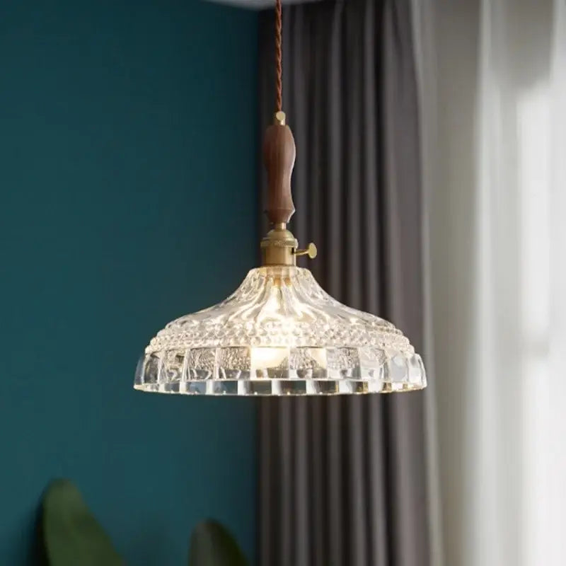 Decorbites led pendant light featuring a clear glass pendant with intricate cuts, warm brass fixture, and dark wood handle