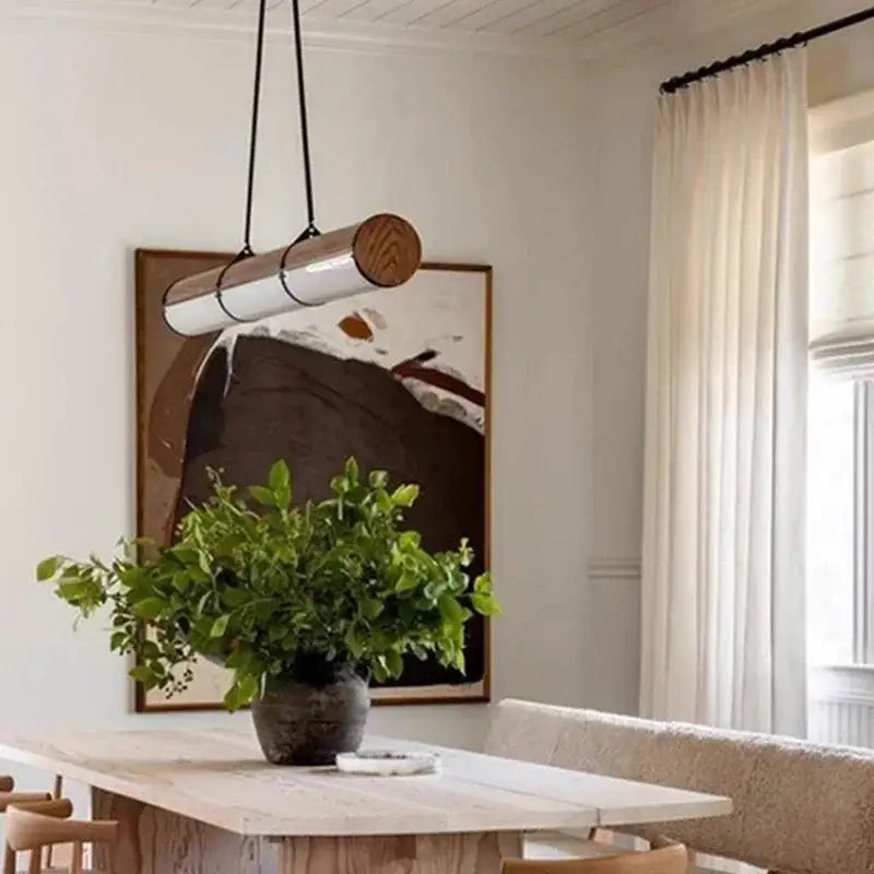 A sleek decorbites led pendant light with polished metal body and wood end caps for modern living and dining rooms