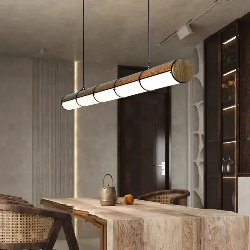 Modern cylindrical DecorBites LED pendant light with natural wood finish and metallic accents for living and dining rooms