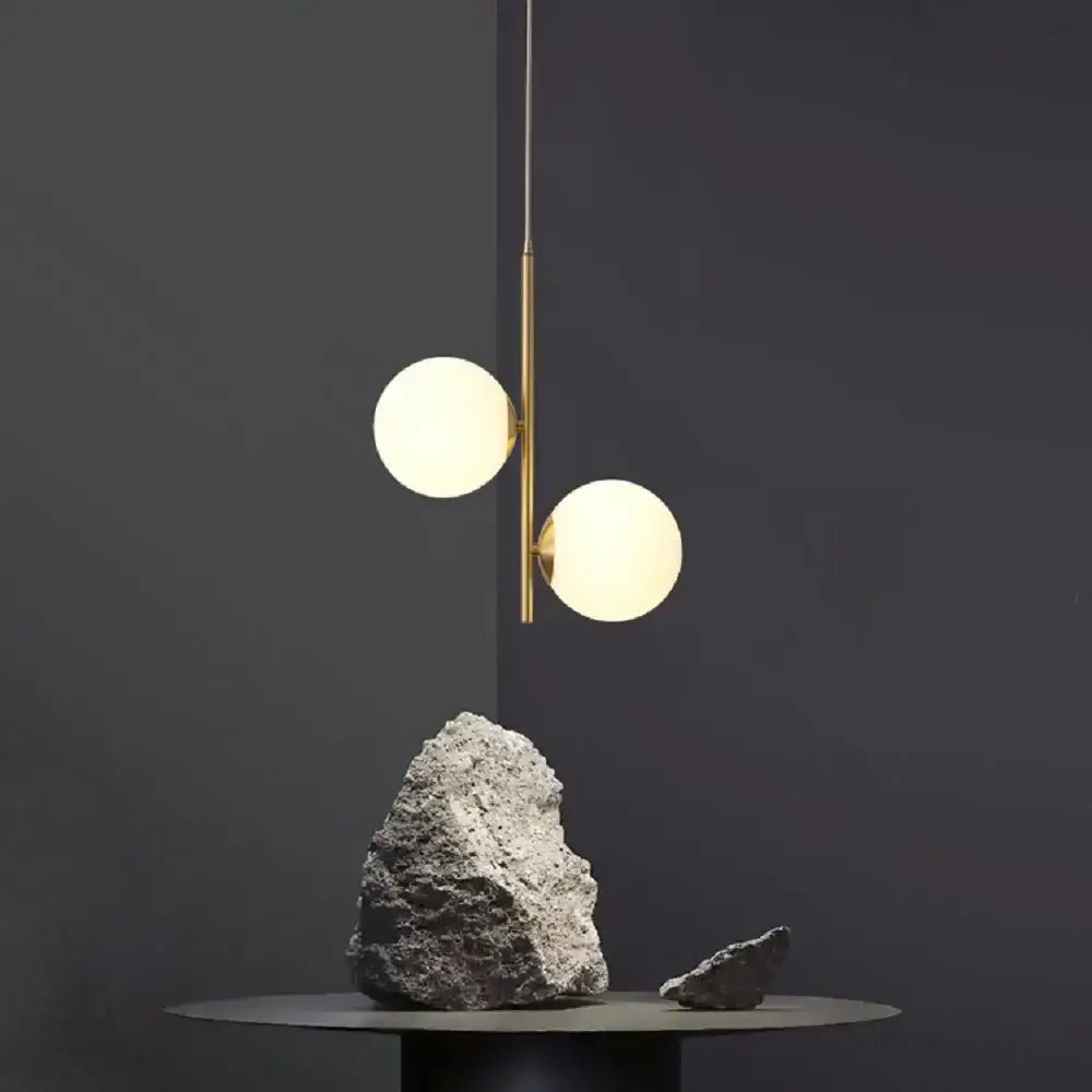 Modern brass decorbites led pendant light with two glowing spherical glass shades for home decor lighting