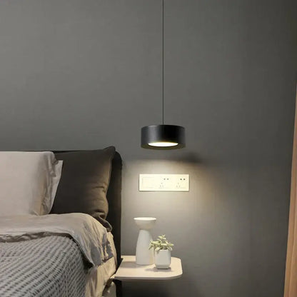 Black cylindrical decorbites led pendant light with modern design hanging above bedside table for bedroom decor
