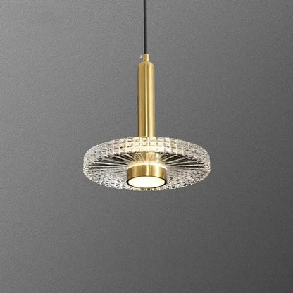 Gold-finished decorbites led pendant light with circular crystal diffuser and central illuminated bulb for indoor use
