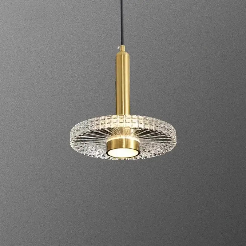 Gold-finished decorbites led pendant light with circular crystal diffuser and central illuminated bulb for indoor use