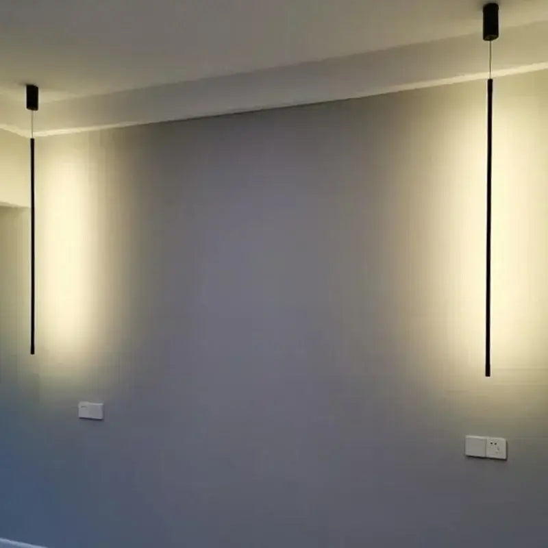 Two sleek black decorbites led pendant lights hang from ceiling emitting warm glow for dining room and bedroom decor