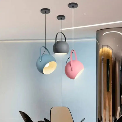 Three modern decorbites led pendant lights with matte blue gray and pink spherical shades for dining decor lighting