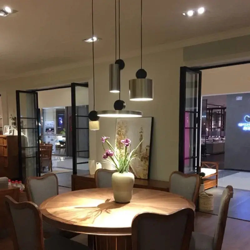Cream-colored ceramic vase with purple flowers on table under decorbites led pendant lights for living room chandelier