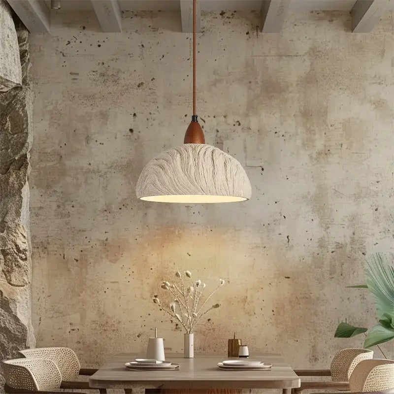 A textured off-white decorbites led pendant light with wooden stem hangs above the dining table in modern decor