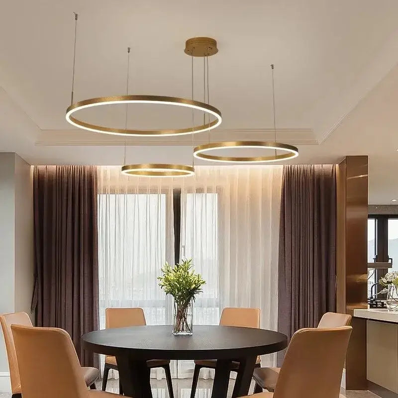 Modern gold-toned decorbites led pendant lights with sleek circular design hang above dining table for kitchen decor