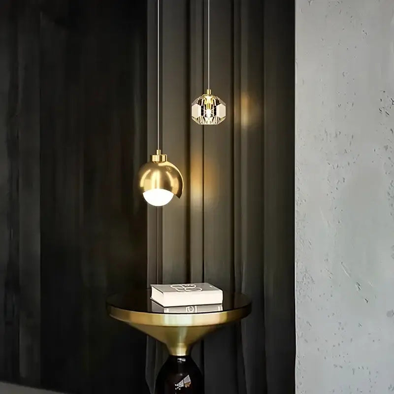 Two elegant decorbites led pendant lights with a polished gold sphere and faceted crystal design for luxury decor