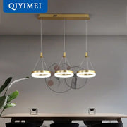 Gold-toned DecorBites led pendant lights with three circular rings suspended from a rectangular ceiling mount