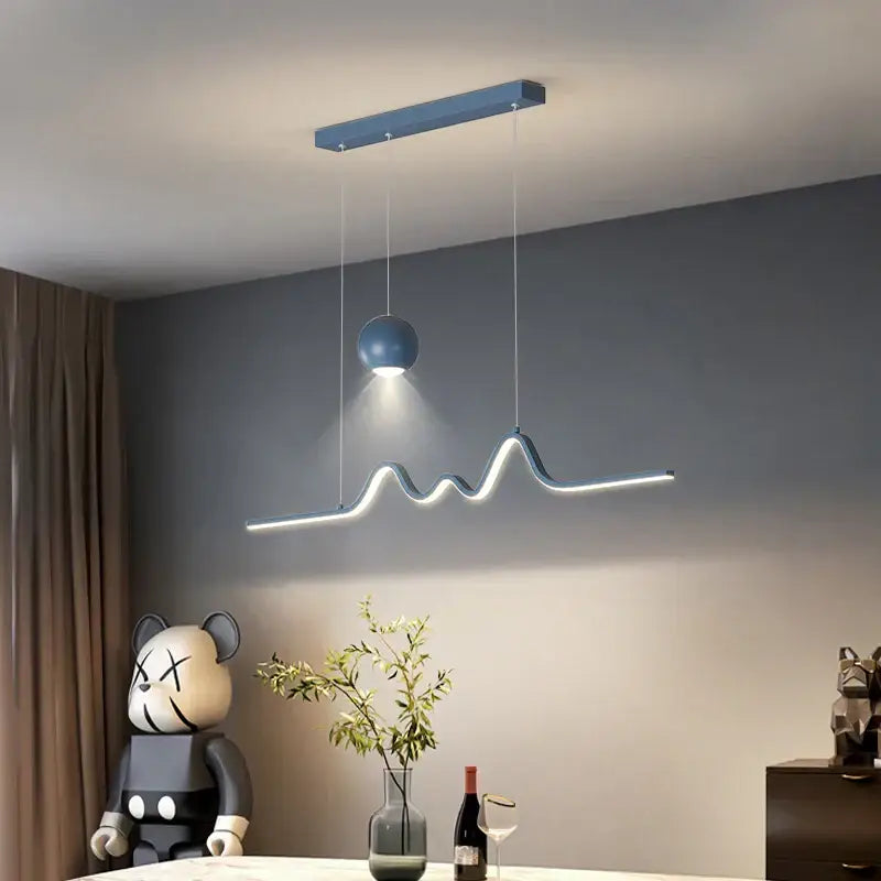 Modern blue DecorBites™ LED pendant lights with sleek wave-shaped design and spherical accent bulb for dining and kitchen island decor