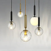 Modern decorbites led pendant lights with clear textured glass globes and brass or black metal fixtures for dining room