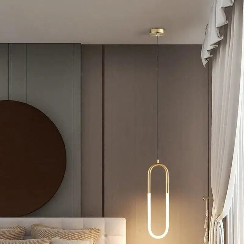 A modern gold-toned decorbites led pendant light with sleek oval design and illuminated led strip for indoor use
