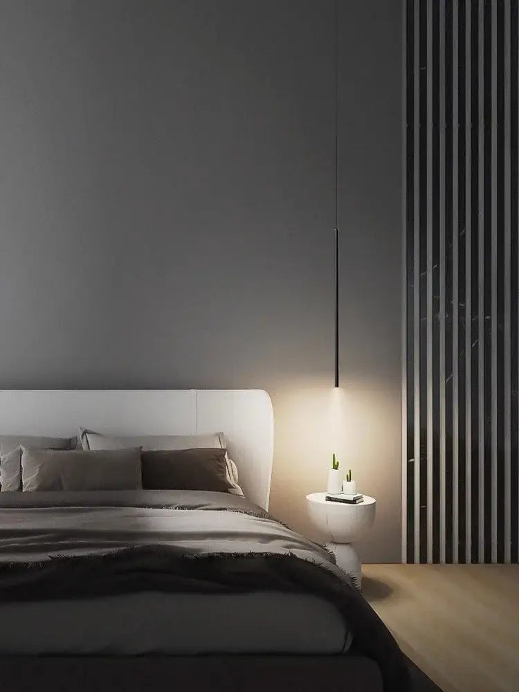 Minimalist black decorbites led pendant light with sleek cylindrical design hanging above bedside table for modern bedroom decor