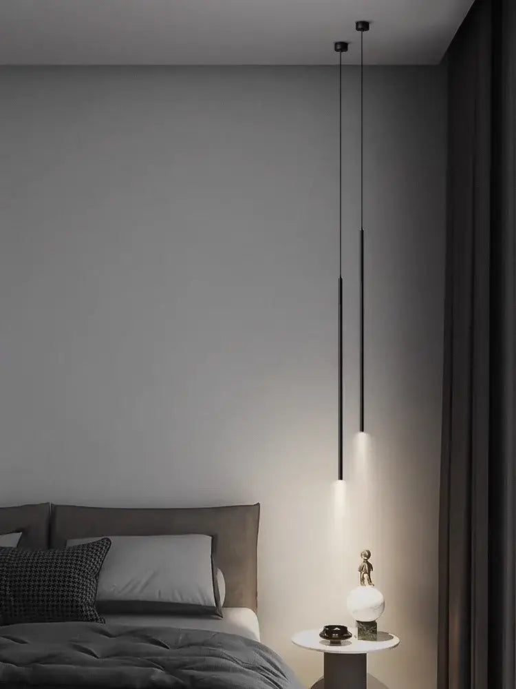 Two sleek black decorbites led pendant lights with minimalist cylindrical design casting warm glow over bedside table