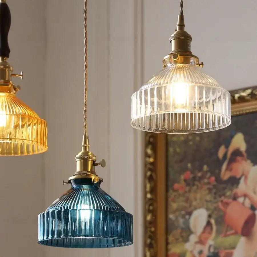 Three vintage-style decorbites led pendant lights with brass fixtures and blue, amber, and clear ribbed glass shades