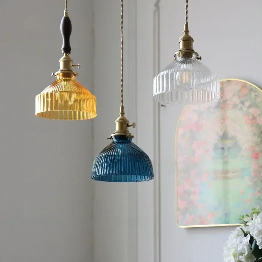 Three vintage-style DecorBites led pendant lights with amber, cobalt blue, and clear ribbed glass shades and brass knobs