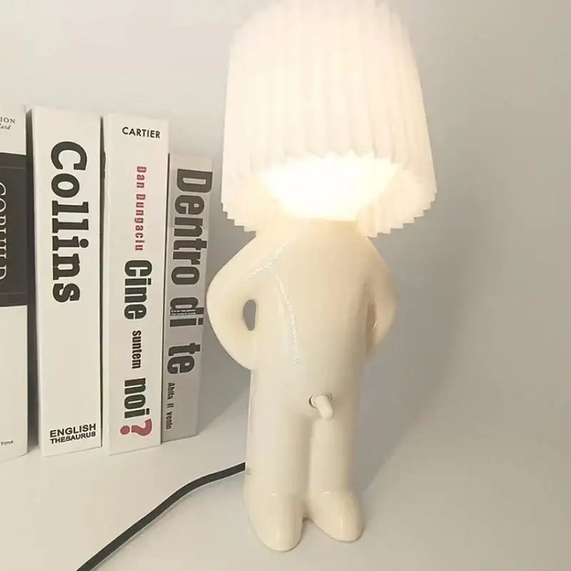 Off-white ceramic table lamp shaped like a stylized humanoid figure with pleated shade decorbites led pleats table lamp