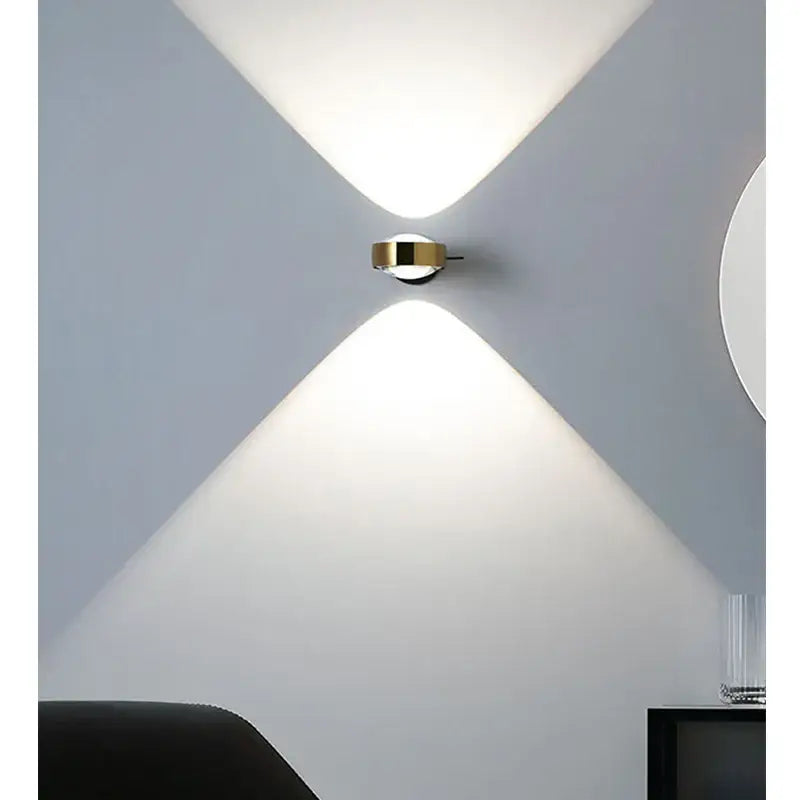Modern gold-toned decorbites led projection wall lamp with sleek circular design casting symmetrical beams of light