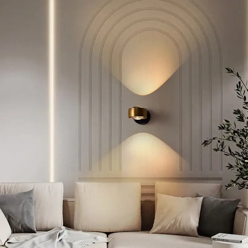 Gold-toned DecorBites led projection wall lamp with sleek modern design casting warm arched light for living room use