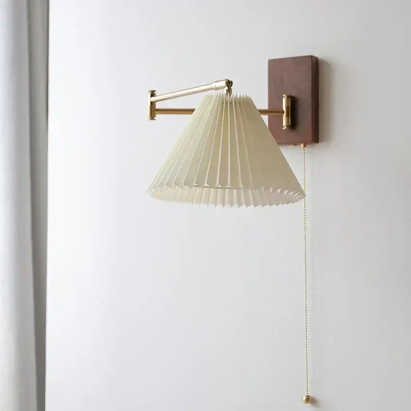 Cream-colored pleated paper shade wall lamp with brass hardware and wooden backplate decorbites led pull chain for bedroom