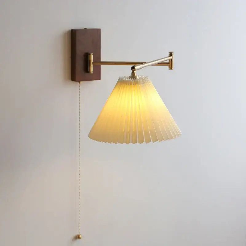 Decorbites led pull chain wall lamp with warm-toned pleated shade mounted on brass arm and dark wood plate for living room