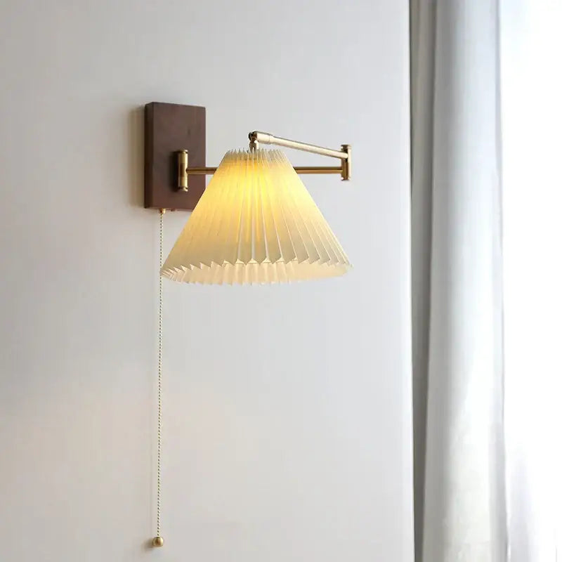 Warm-toned brass decorbites led pull chain wall lamp with pleated off-white paper shade and adjustable arm for bedroom