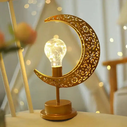 Golden crescent moon-shaped table lamp with intricate cut-out floral star patterns and glowing led bulb decorbites led ramadan