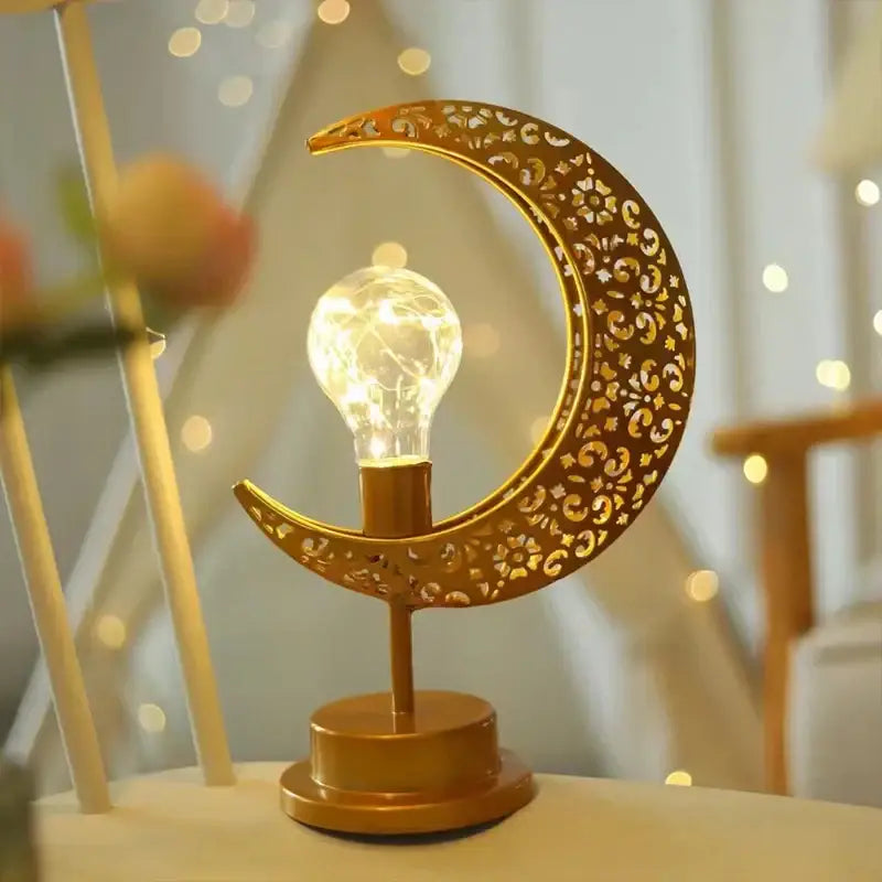 Golden crescent moon-shaped table lamp with intricate cut-out floral star patterns and glowing led bulb decorbites led ramadan