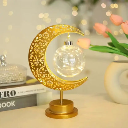 Golden crescent moon-shaped table lamp with intricate cut-out patterns and clear glass globe for decorbites led ramadan use