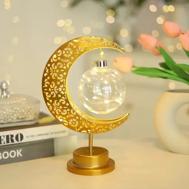 Golden crescent moon-shaped table lamp with intricate cut-out patterns and clear glass globe for decorbites led ramadan use