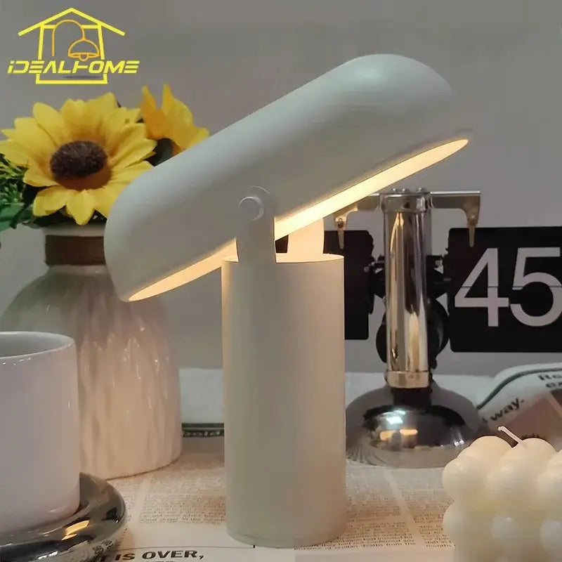 A sleek off-white decorbites led rechargeable table lamp with adjustable curved shade emitting warm light for modern decor