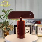 A sleek glossy burgundy decorbites led rechargeable table lamp with cylindrical base and dome-shaped shade for bedroom use