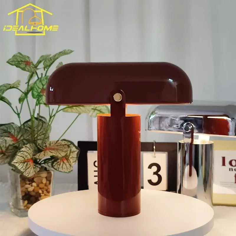 A sleek glossy burgundy decorbites led rechargeable table lamp with cylindrical base and dome-shaped shade for bedroom use