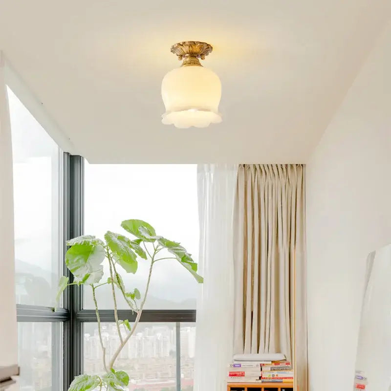 A warm frosted glass ceiling light fixture with a golden ornate resin copper base by decorbites led resin
