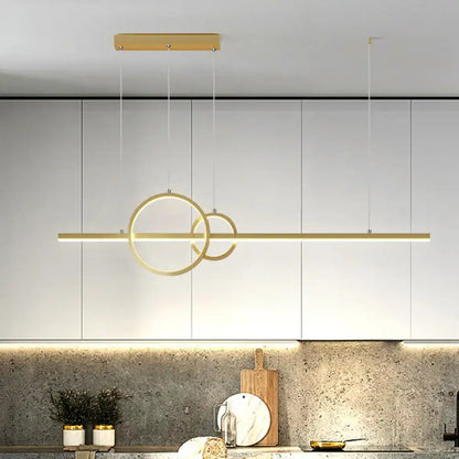 Modern gold-toned decorbites led restaurant island pendant with intersecting rings and warm white lighting above counter