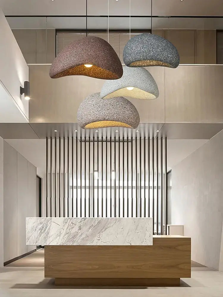 Three dome-shaped decorbites led restaurant pendant lights with textured earth tones above marble wood desk