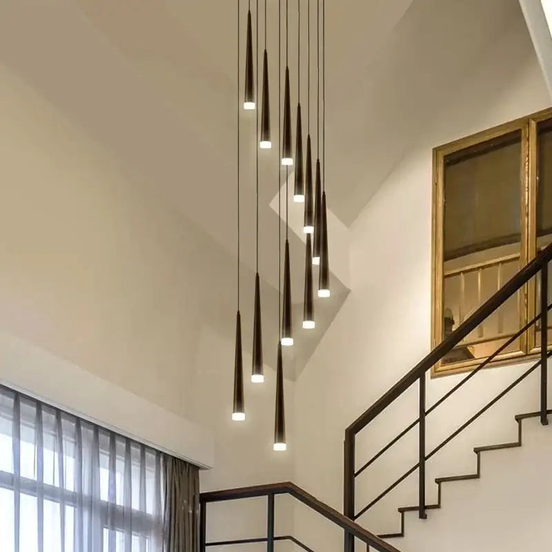 Modern black conical pendant lights with warm bulbs in a staggered ring chandelier for indoor home decor by decorbites