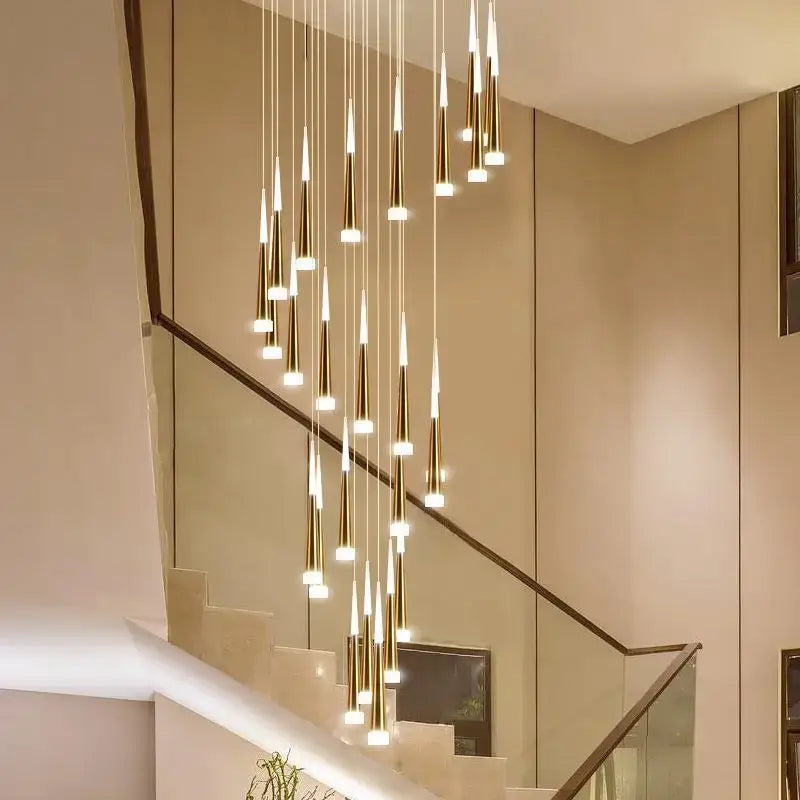 Modern gold-toned decorbites led ring chandelier with slender tapered pendants in a cascading indoor lighting design