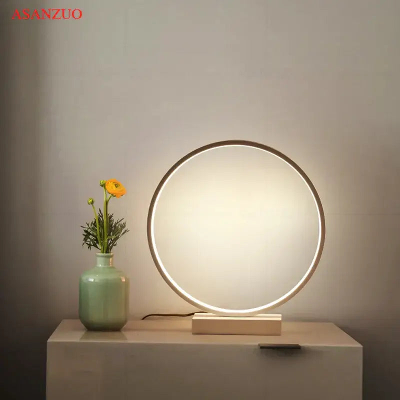 DecorBites™ led ring table lamp with a sleek metallic frame and warm glow on a minimalist wooden base for bedroom lighting