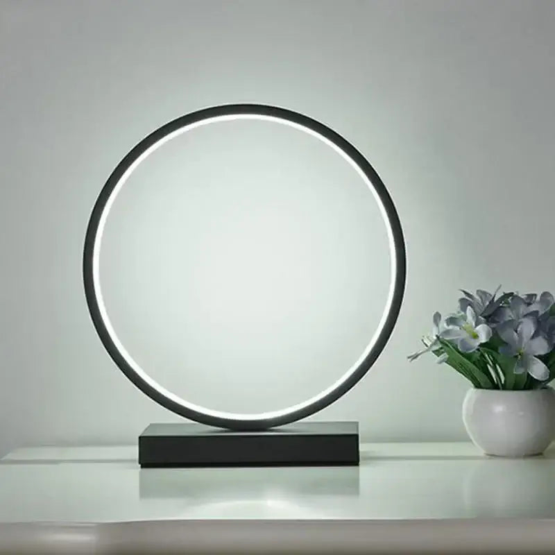 Modern black circular led ring table lamp with sleek minimalist design and glowing ring for bedroom lighting by decorbites