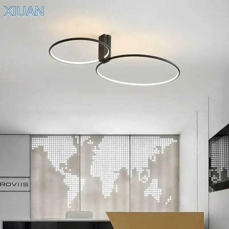 Modern black led round ceiling lamp with two intersecting rings and metallic mounting bracket by DecorBites™