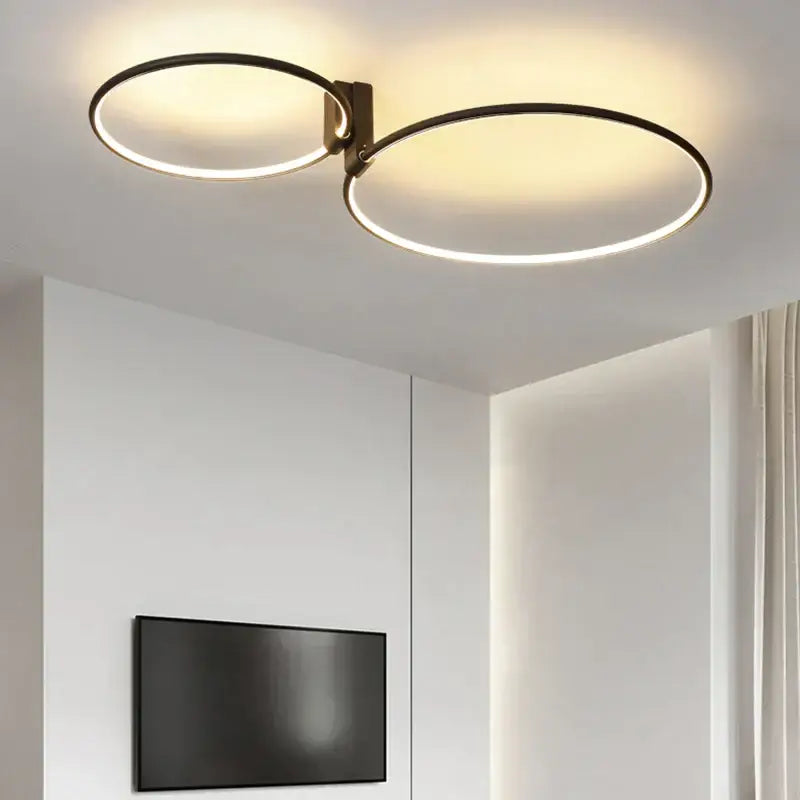 Modern black led round ceiling lamp with two interlocking rings emitting warm glow in white black gold aluminum