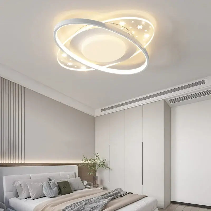 Modern white led round ceiling light with sleek intertwined rings and star-shaped cutouts emitting warm glow for indoor use