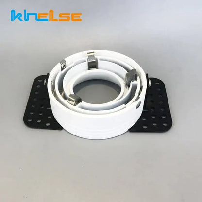 White coiled cable clamp with metallic silver clips and black perforated mounting plates for decorbites led round recessed ceiling fixture